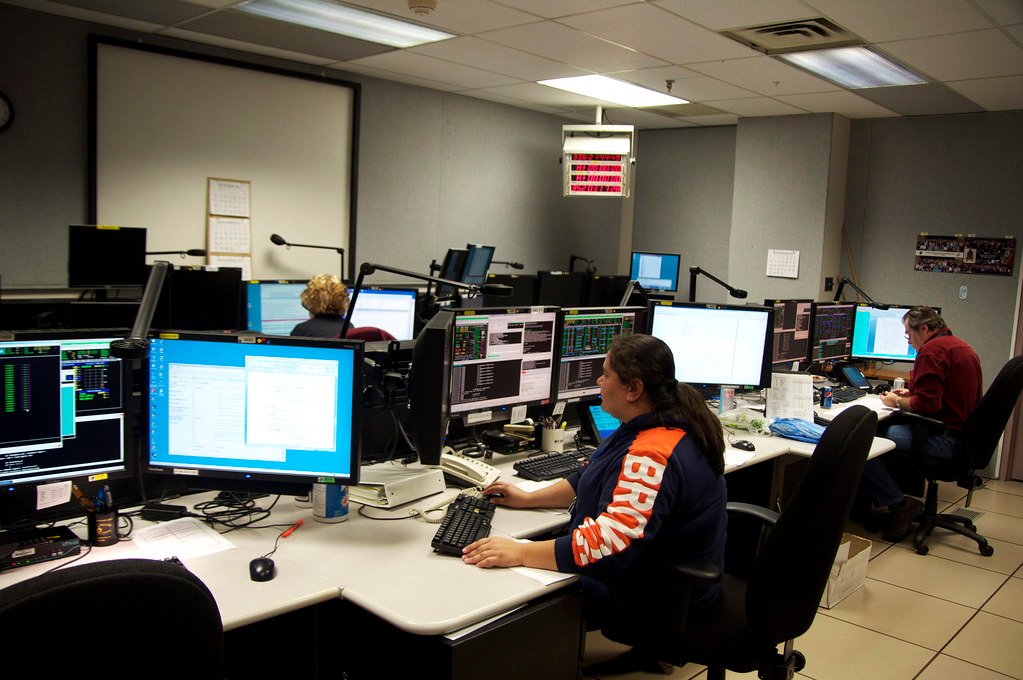 Operators monitoring banks of screens in a mission control room