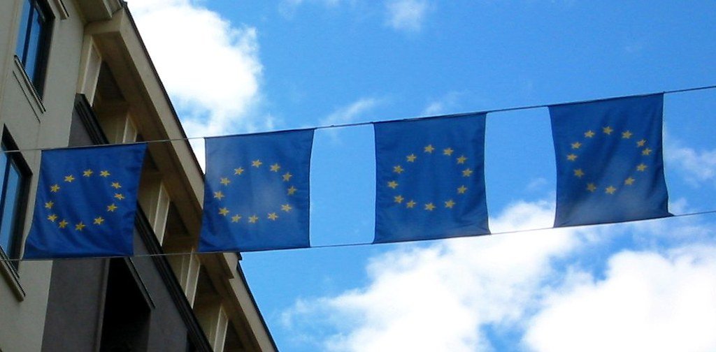 European Union flags flying outside an institutional building