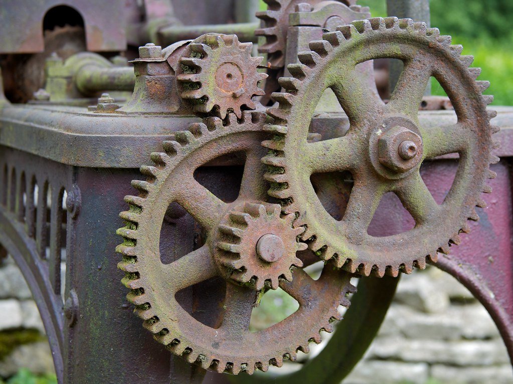 Interlocking mechanical gears, each turning on a fixed path